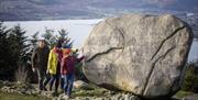 Images depicts a family at the Cloughmore Stone in Rostrevor. © Tourism Ireland photographed by Brian Morrison