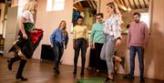 Girl being shown how to dance by the instructor as the rest of the group watches on as part of the Dancing at the Crossroads experience