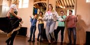 Girl enjoying dancing as she's taught by the instructor as part of the Dancing at the Crossroads experience