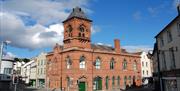 Red brick exterior with town hall clock of Down Arts Centre that sits at the junction of Irish Street, English Street and Scotch Street in Downpatrick