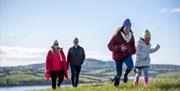 Family enjoying a walk to Strangford Stone in Delamont Country Park.