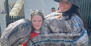 A dino being cuddled in a sling