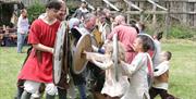 Magnus Vikings re-enacting battle with young children dressed up in Viking costume