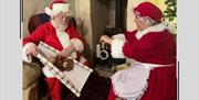 Santa and Mrs Claus wrap presents together
