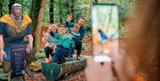 An image of a family enjoying the Fionn's Giant Adventure at Slieve Gullion Forest Park alongside Fionn the giant.