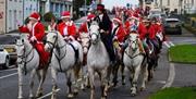 Many horses on the main street in Saintfield. Riders all dressed up in santa suits.