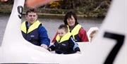 Family enjoying the swan boats on the lake at Castle Park, Newcastle