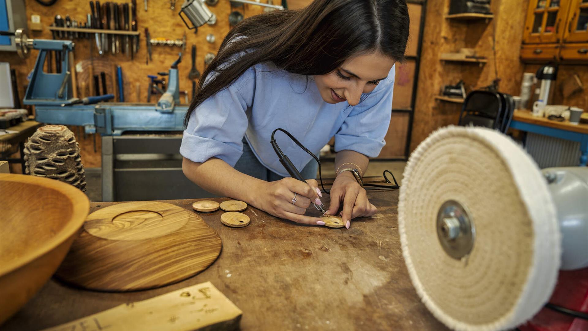Woman starts imprinting on her handmade wooden pendant