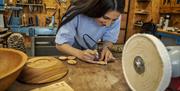 Woman starts imprinting on her handmade wooden pendant