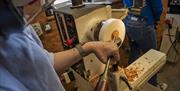 Participant has a go crafting their own wood pendant