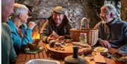 Three people enjoy Foraged Food around a table with Brian from Mountain Ways Ireland