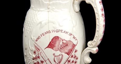 A jug printed with the phrase 'who fears to speak of '98?'  in red, which was made to commemorate the centenary of the 1798 rebellion.