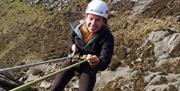 Woman loving a huge abseil in the Mournes
