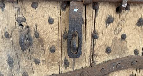 Section of a door from the olg gaol, now the Down County Museum. It features metal bars and reinforcing nails  to strengthen it.