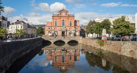 Picture of Newry Town Hall with a reflection of the hall in the Clanrye River infront.