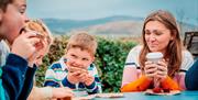 A family dining outside at Fionn's Giant Adventure at Slieve Gullion Forest Park.