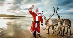Picture of Santa on the beach with two reindeer