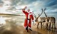 Picture of Santa on the beach with two reindeer