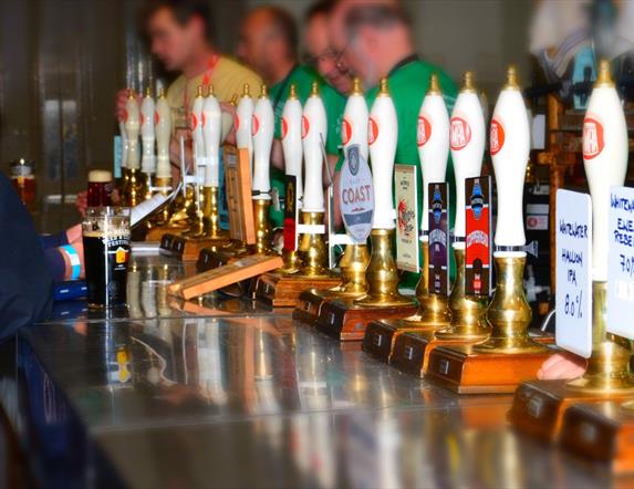 A bar with a row of hand pumps behind it