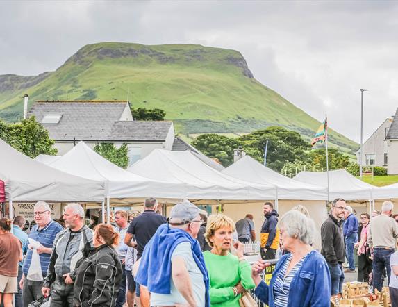 People browsing busy outdoor market stalls