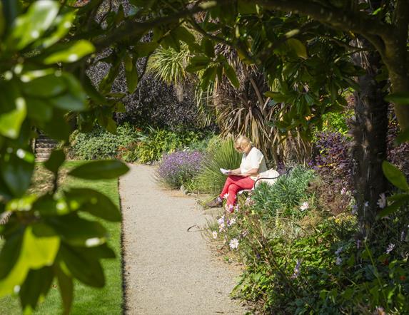 A woman taking a moment to reflect on the bench in Castle Ward's Sunken Garden