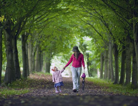 Mother and Daughter walking hand-in-hand down Lime Tree Walk in Castle Ward Estate