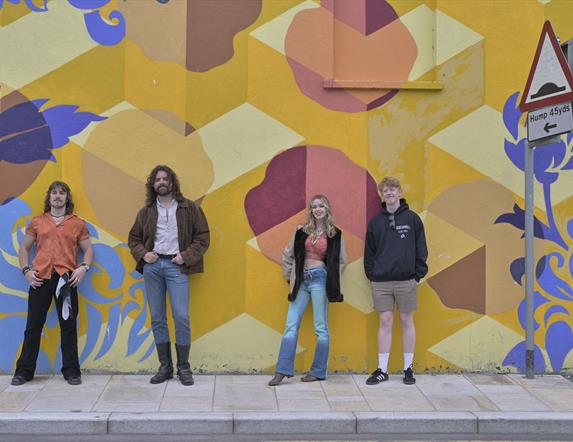 Banshee the overall winners from Buskfest 2024 pictured against street art in Banbridge.