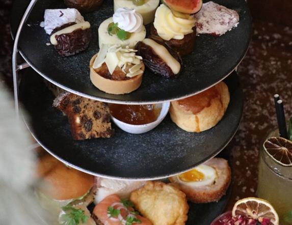3 tier afternoon tea stand with savoury and sweet treats with cocktails & mocktails