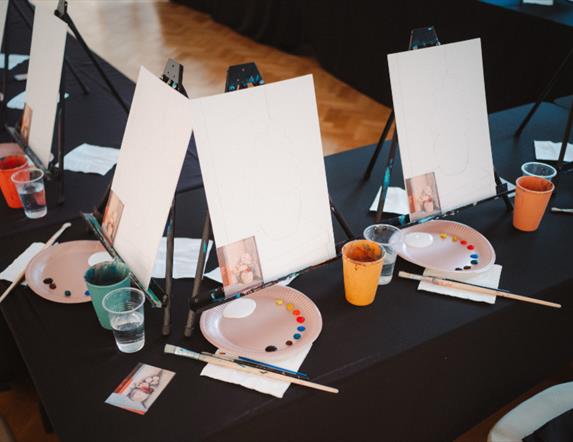 Photo of canvases, paint palettes and glasses of prosecco in the Ulster Museum