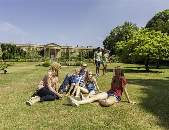 Family sitting on grass in front of Hillsborough Castle