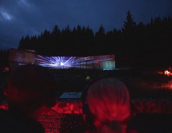 Image of the OM building light up with a projection