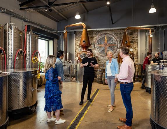 Tour group admire the stills within the Copeland Distillery