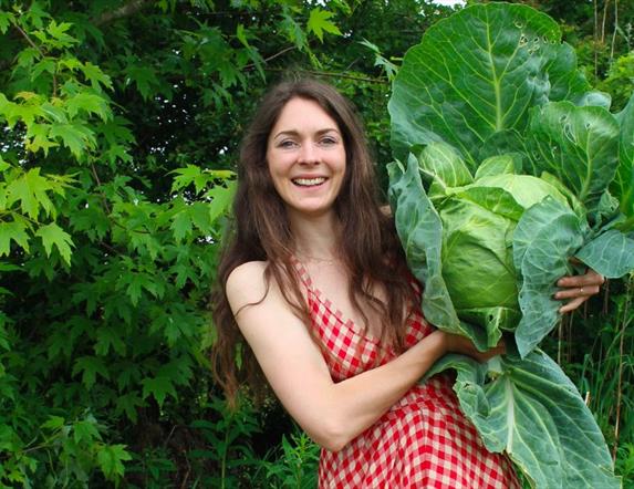 a woman holds a large cabbage