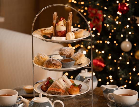 Festive afternoon tea set up with christmas tree in background
