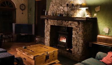 Cosy living room with stone fireplace and burner