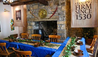 Room set up for Dobbins dining experiece as part of Dobbins Dander and Dine with seats and long tables in front of a large fireplace.