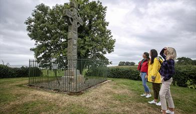 Three ladies looking up at Ardboe High cross