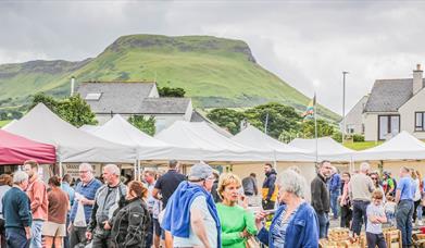 People browsing busy outdoor market stalls