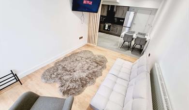 Open floor plan including lounge area with TV and kitchen area.