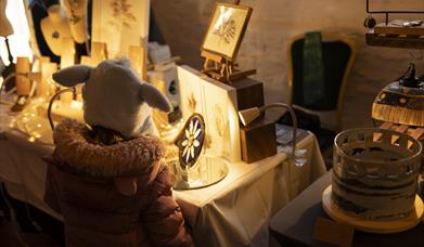 Little girl looking at glasswork crafts at Castle Ward