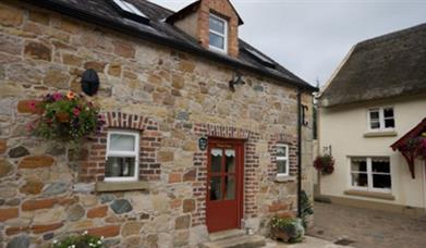 entrance to cottage with red door and stone walls