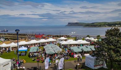 crowds of people browsing busy seaside market stalls