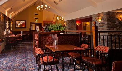 A restaurant dining area with tables, chairs and a seating booth.