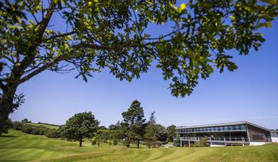 Image shows main building with golf course and trees