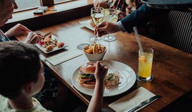 A family enjoying dinner and being served wine.