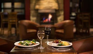 Table set for two with meals and glasses of wine