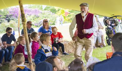 A storyteller is talking to children on the grounds of Hillsborough Castle and Gardens