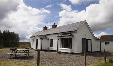 outside image of house with picnic table at front