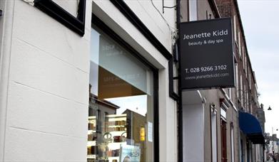 Image shows signage of Day Spa at front of property, its is dark grey with the text in white writing