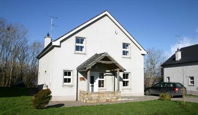 Large white two store house with stone porch feature